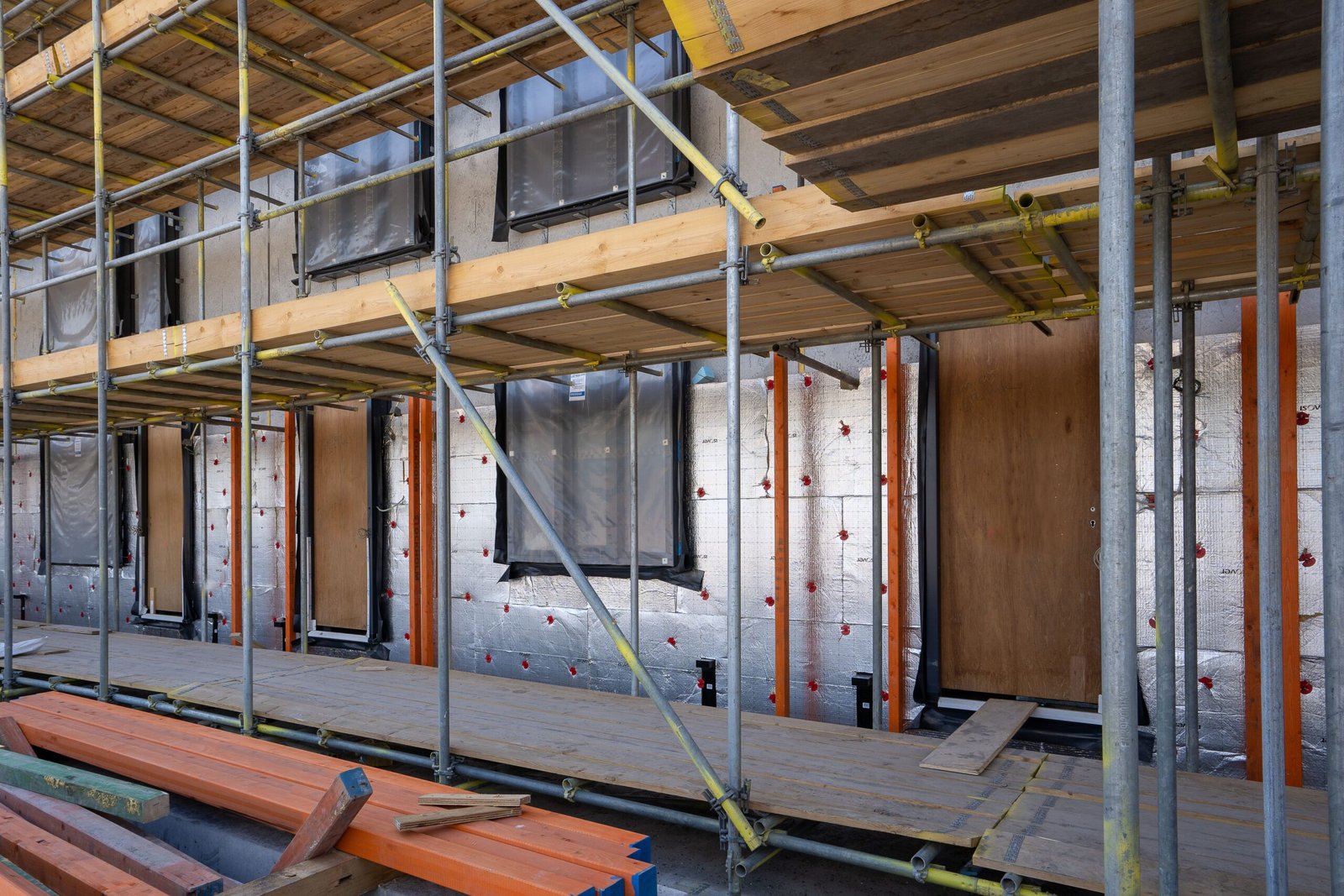 Échafaudage sur une façade de maison ancienne avec panneaux d'isolation lors d'une rénovation globale