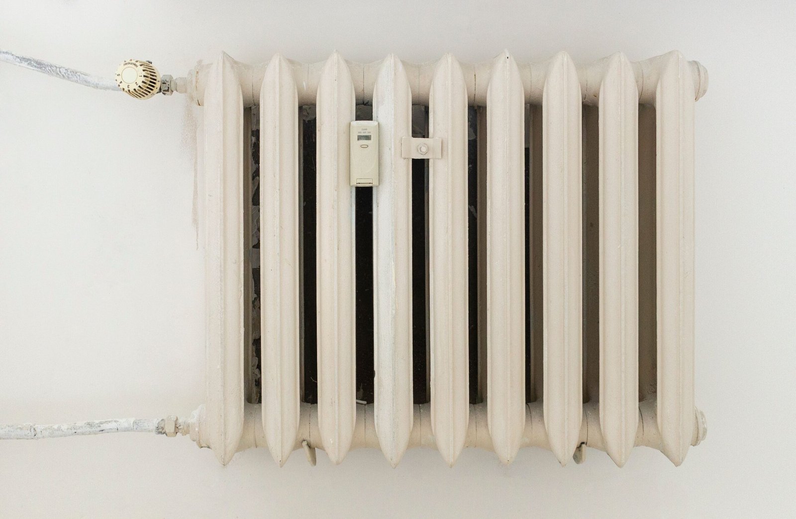 Radiateur blanc alimenté par une pompe à chaleur air-eau dans un salon rénové