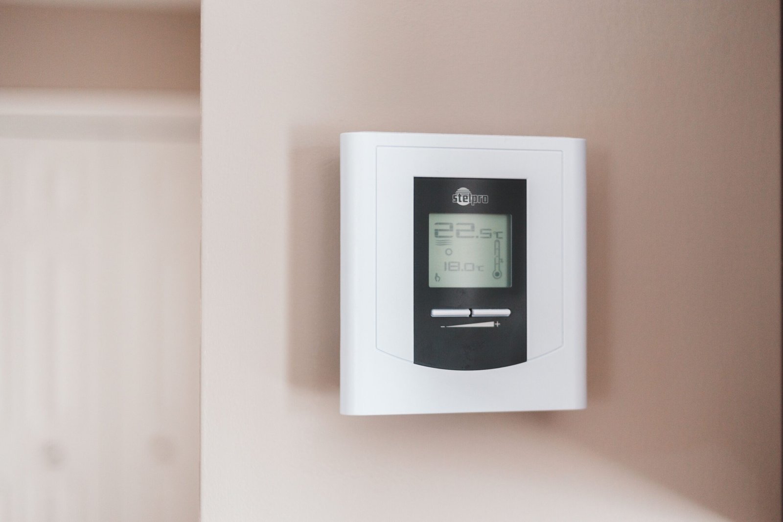 Thermostat blanc fixé au mur pour réguler la température