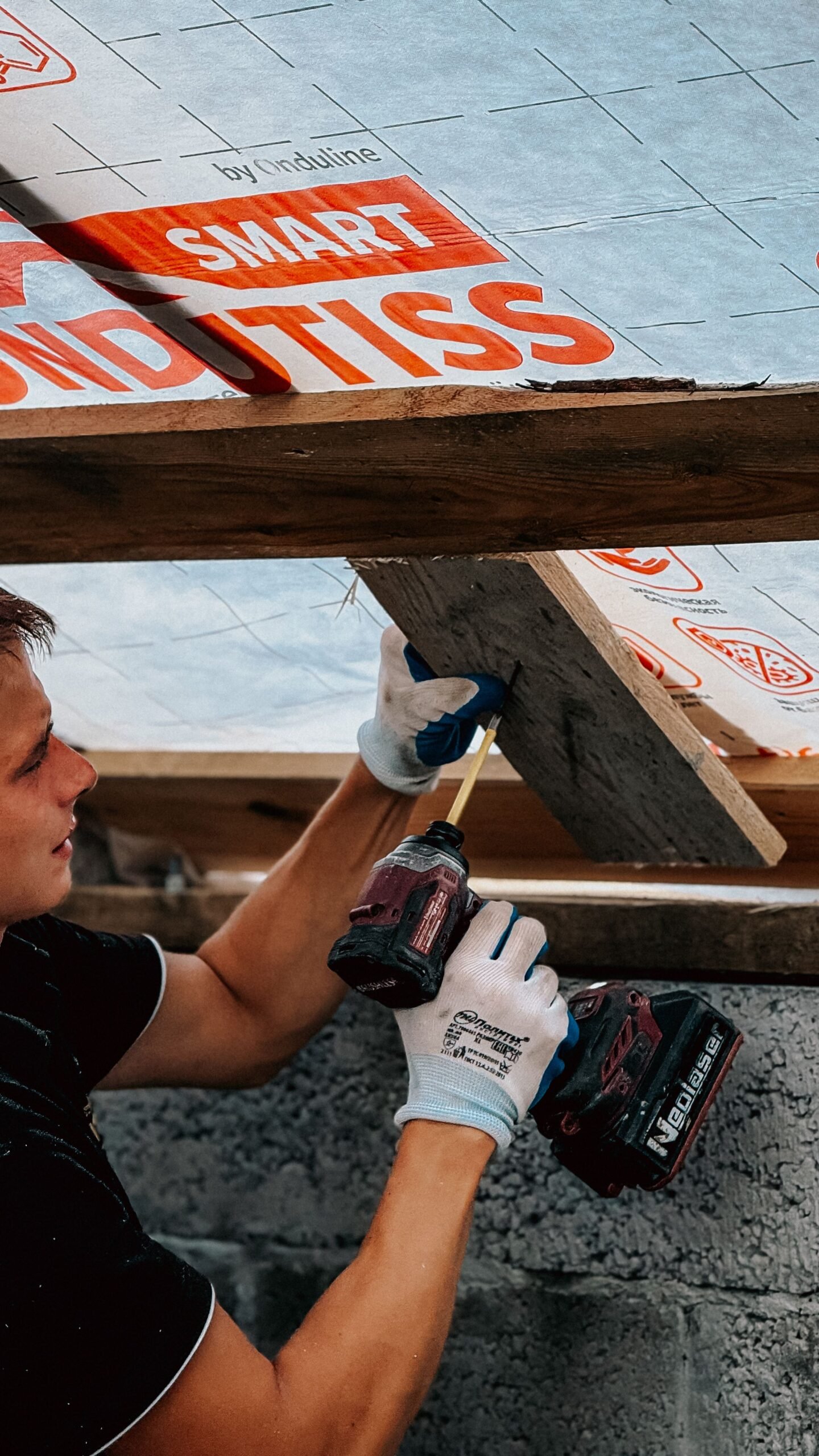 Ouvrier installant une isolation de toiture dans le cadre de travaux éligibles à MaPrimeRénov'
